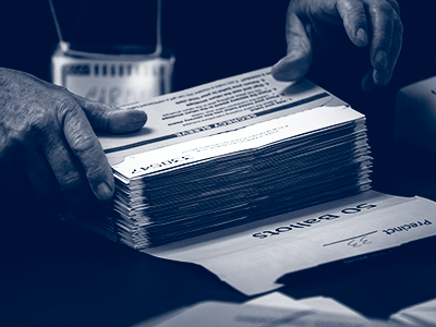 hands holding stack of ballots